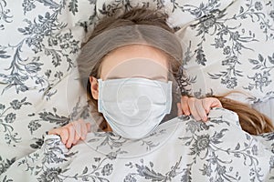 Close eyes. girl lying in bed in a medical mask.