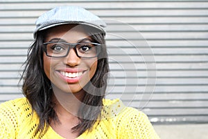 Close face of African female with glasses and newspaper boy hat