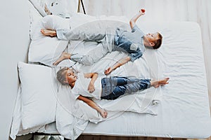 Brother and sister sleeping on bed after playing