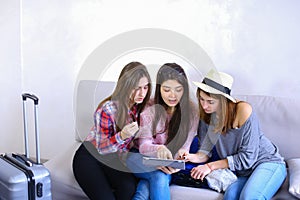 Close female friends use tablet and have fun, sit on couch in ro