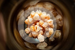 Close focus on small dried longans preserved inside glass jar