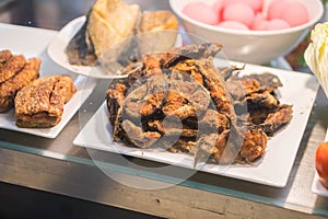 Close-fried crispy fish pieces on a plate heaped with old wooden