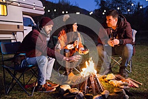 Close friends ejoying the heat from their camp fire