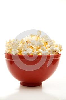 Close Front View of Buttered Popcorn in a Red Bowl Isolated on White