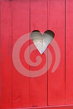 Close on a heart-shaped on a red wooden shutter