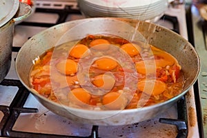 Cooking fried eggs on frying pan close up