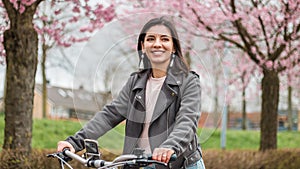 Close portrait of beautiful multi-ethnic Turkish woman 20-29s riding a bike in the city street