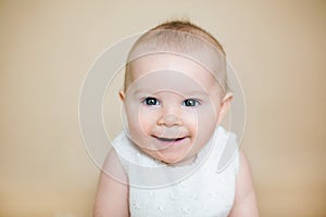 Close portrait of cute little baby boy, isolated on beige background, baby making different facial expressions, smiling, laughing