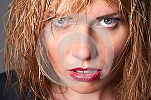 Close portrait of edgy young blond fashion model with wet hair &