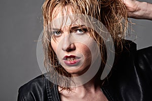 Close portrait of edgy young blond fashion model with wet hair &