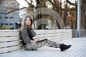 Close portrait of gorgeous dark-hair woman student using laptop computer at campus, charming female teenager studying on