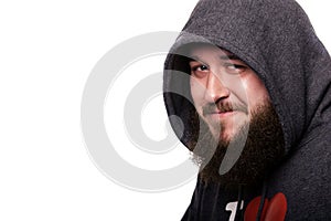 Close portrait of a guy with a beard and mustache in kapyushone.Emu very fun constrains smile. Isolated on white background