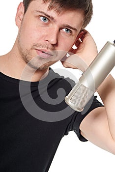 Close portrait of handsome young man singing into studio microp