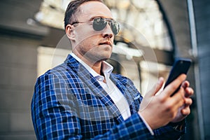 Close portrait of a man. businessman holding a phone. wearing a blue jacket and a white shirt. busy