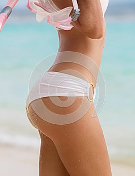 Close portrait of Young woman with wet skin and with a snorkeling equipment on sand and going to swim in clear ocean