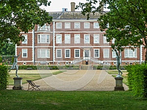 Close rear view of Ham House, framed by statues and trees
