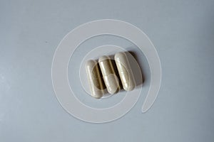 Close shot of 3 beige capsules of Saccharomyces boulardii probiotic
