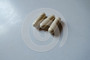 Close shot of 3 light beige capsules of Saccharomyces boulardii probiotic