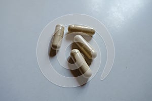 Close shot of four beige capsules of Saccharomyces boulardii probiotic