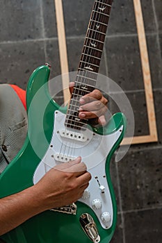 Close shot of a green guitar being played by a musician