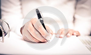 Close shot of a human hand writing something on the paper