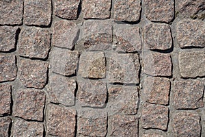 Close shot of pavement made of pink granite stone setts