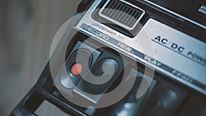 Close shot of pressing `record` button on a retro 1970s audio cassette recorder