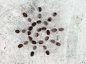 Close shot of roasted coffee beans in sun shape on white background