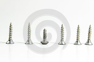 Close side shoot of multiple screws on white blurry background