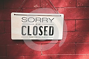 Close sign hanging on red stone wall texture background