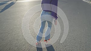 Close slomo from behind of girl in jeans roller skating, no face