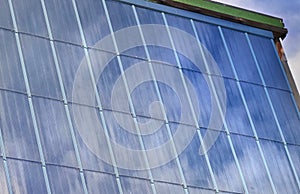 Close on solar panel with cloudy sky reflection