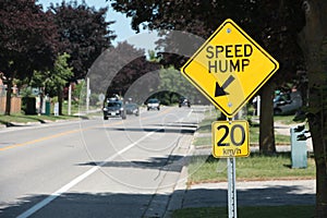 close on speed hump arrow 20 km/h sign in black writing on yellow background