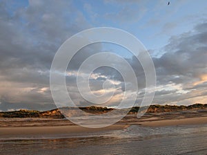 Evening sky with dark rainclouds and fiery sunlight reflections at Findhorn Bay, Scotland photo