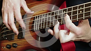 Close-u male fingers playing solo on bass guitar