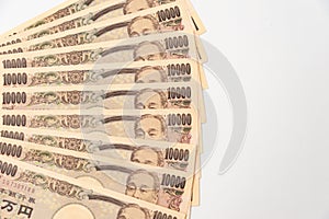 Close-up of 100,000 yen stacked in layers of 10,000 yen banknotes.