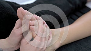Close-up 4K video of woman enjoying thai foot massage in professional salon