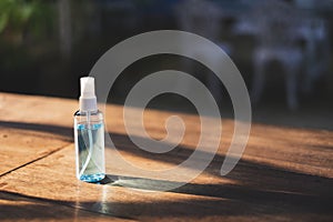 Close-up of 70% Blue Ethyl alcohol spray bottle on the wooden desk. Use for Coronavirus Protection