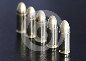 Close up of 9 mm golden pistol bullets ammo on background