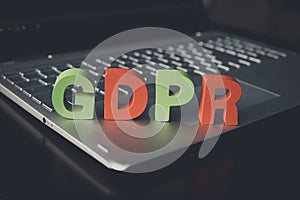 Close up of abbreviation GDPR set on the bottom of laptop standing on white table. Concept of personal data control and protection