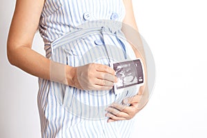 close-up. The abdomen of a pregnant woman and an ultrasound scan of the child. Waiting for children. White background