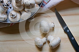Close-up from above of a cutting board with mushrooms and a knife