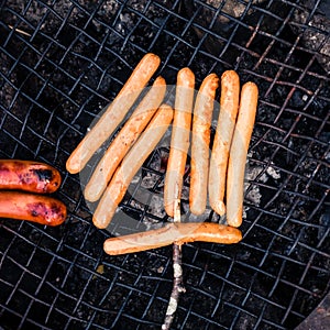 Close up from above of grilling hot dogs outdoors