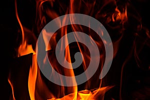 Close up. Abstrack background. Orange flame in the fireplace. Fire in the darkness. Copy space