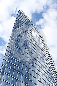 Close up abstract modern skyscraper architecture tall glass building with clouds in background