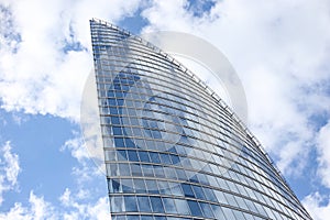 Close up abstract modern skyscraper architecture tall glass building with clouds in background