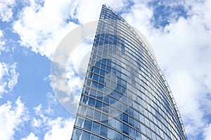 Close up abstract modern skyscraper architecture tall glass building with clouds in background