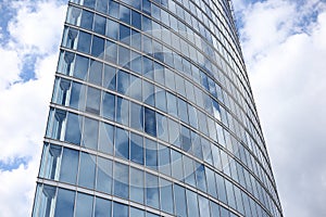 Close up abstract modern skyscraper architecture tall glass building with clouds in background