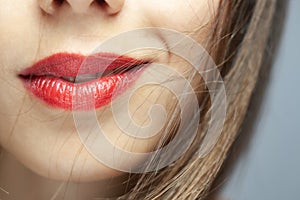 Close up abstract portrait of a beautiful caucasian girl with red lipstick. Windy hair blowing on face