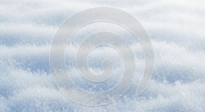 Close-up abstract texture of soft, rippling snow surface pattern